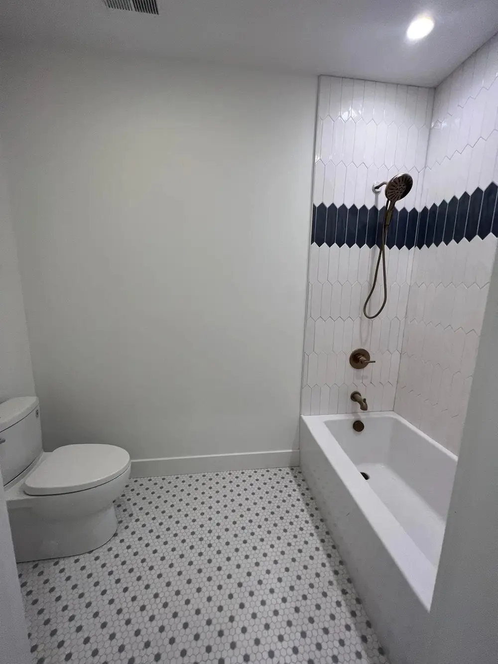 A bathroom remodel with a tiled tub surround
