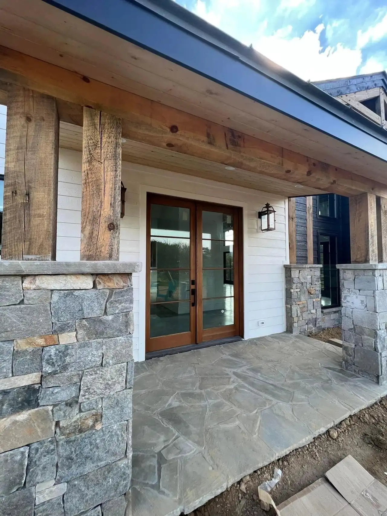 A covered entry in stone and reclaimed timber